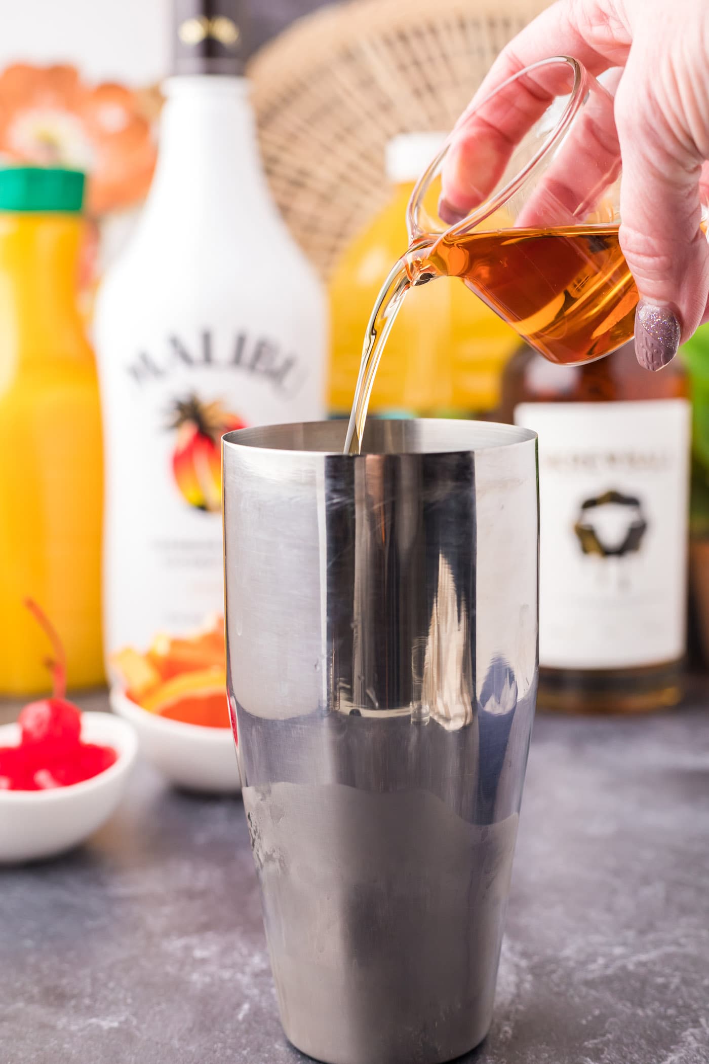 pouring peanut butter whiskey into cocktail shaker