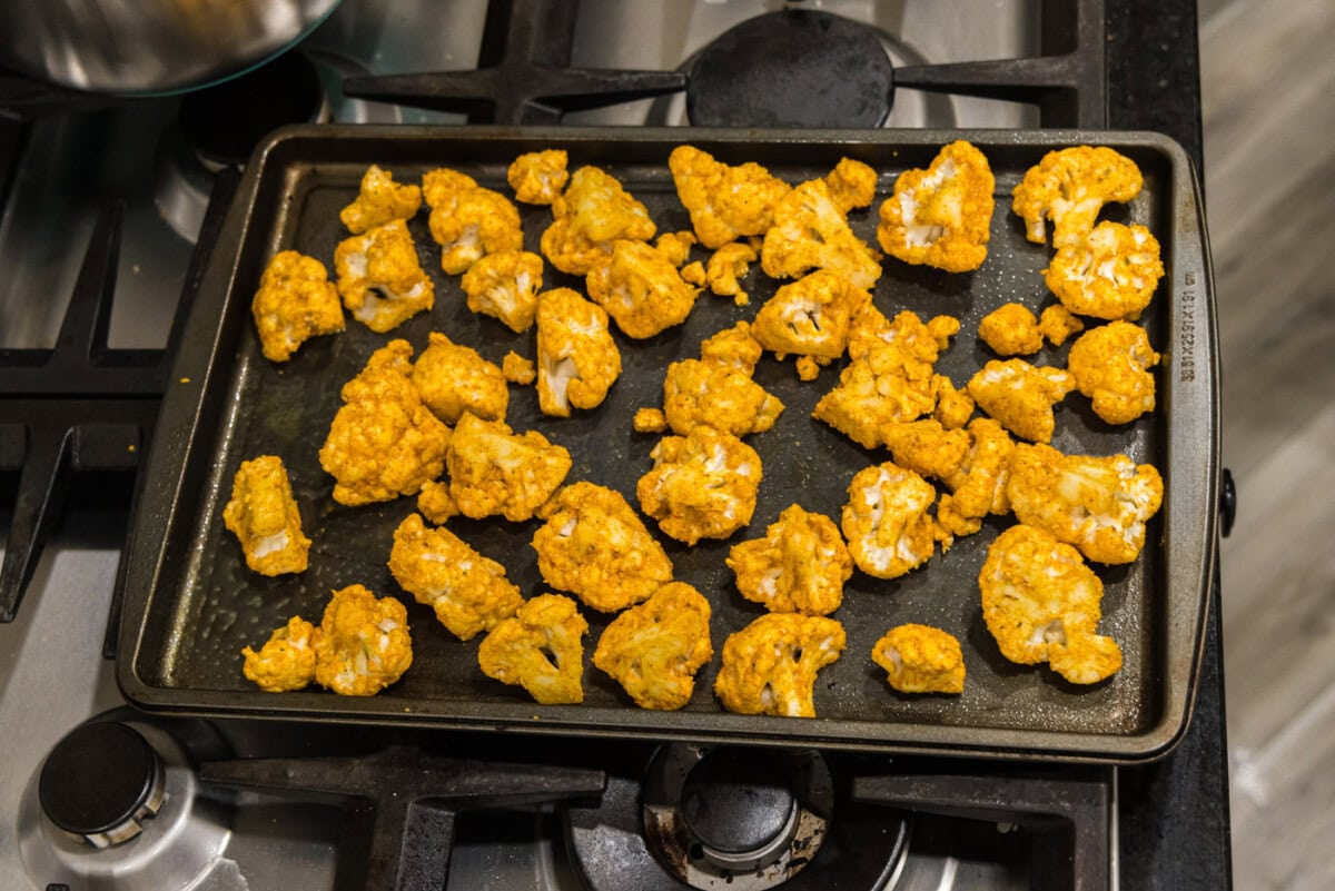 spicy cauliflower florets on a baking sheet