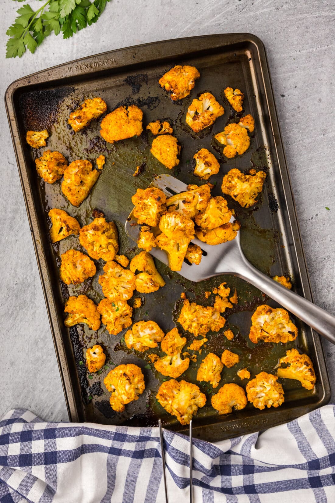 Spicy Roasted Cauliflower on a sheet pan with a spatula
