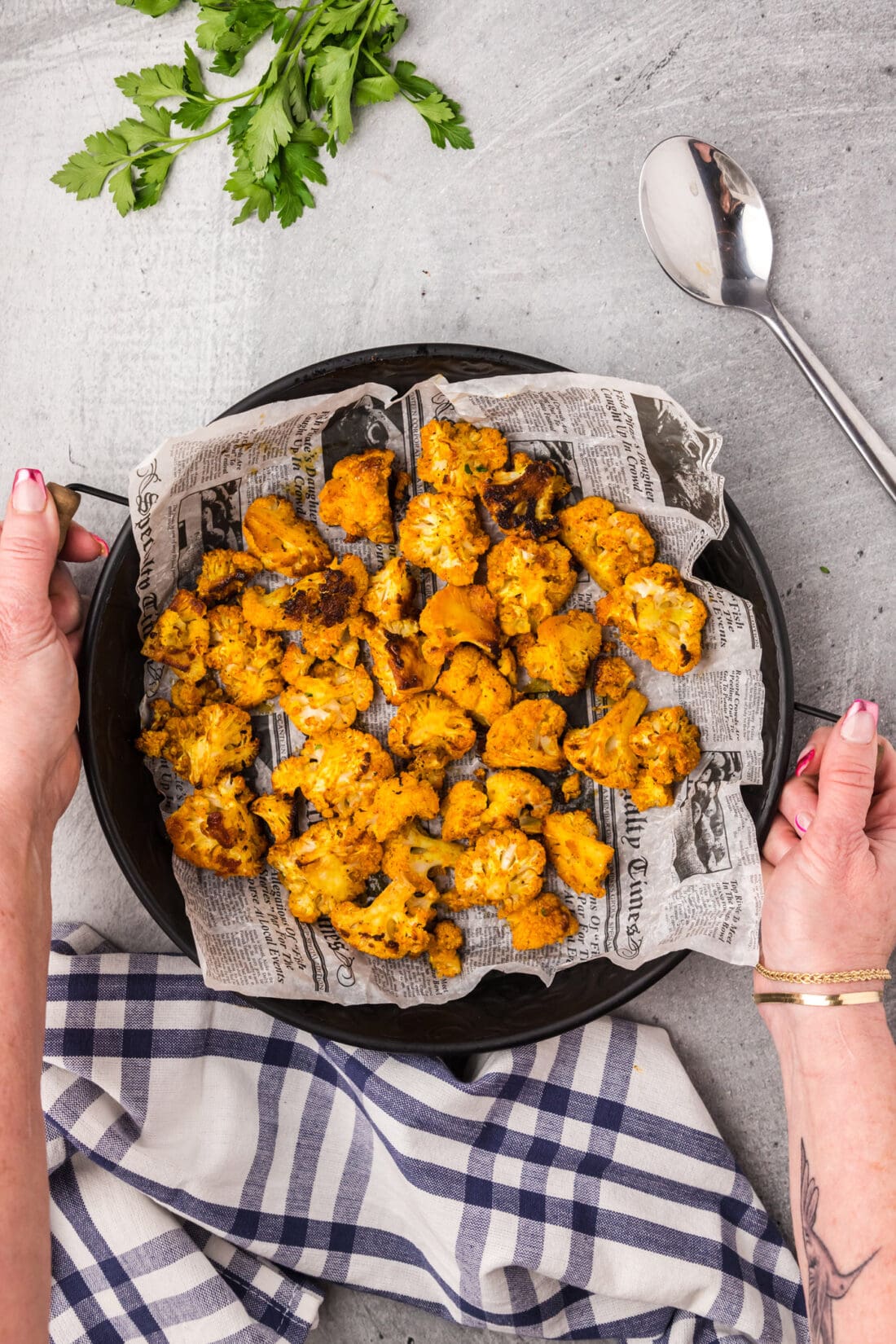 Hands holding a serving tray of Spicy Roasted Cauliflower
