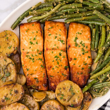 Close up photo of Brown Sugar Salmon served on a platter with garlic green beans and melting potatoes
