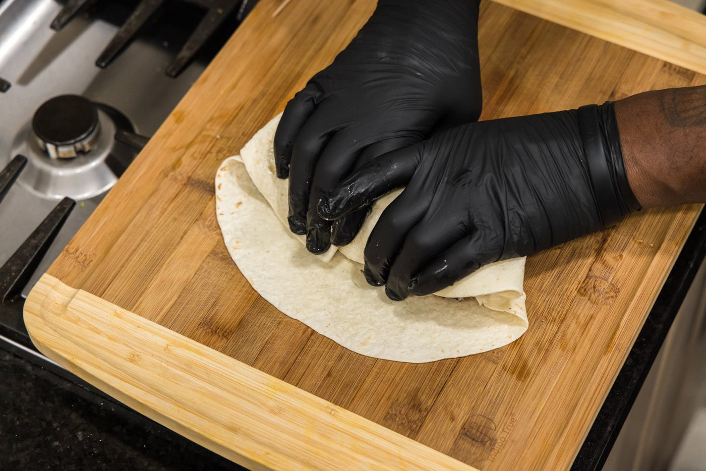 hands rolling a burrito