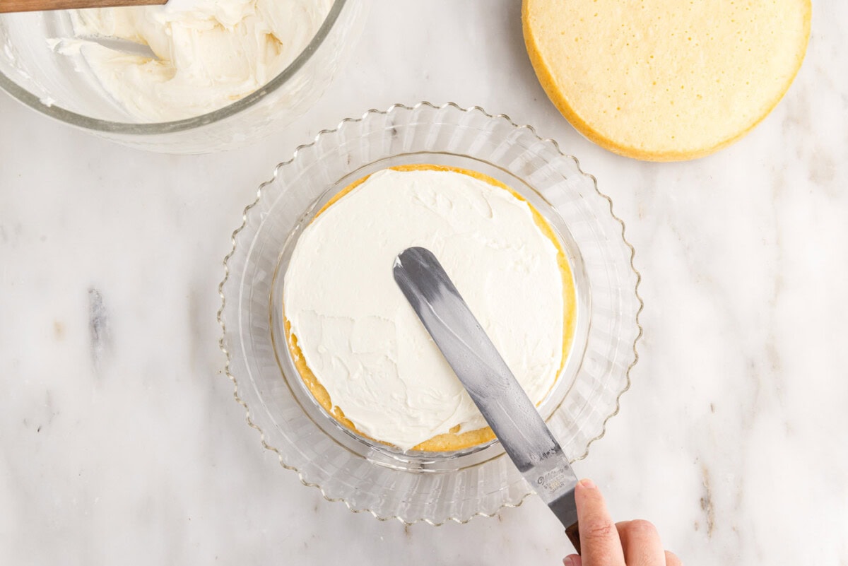 spreading frosting over cake