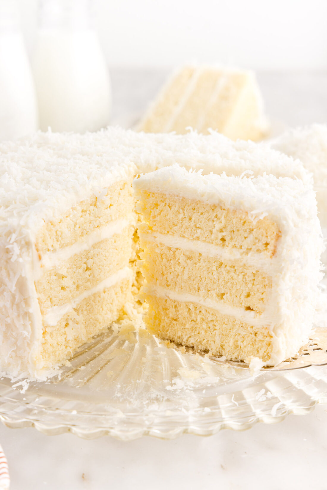 Coconut Cake on a cake plate with slices removed