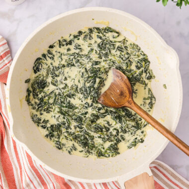 Skillet of Creamed Spinach with a spoon in it