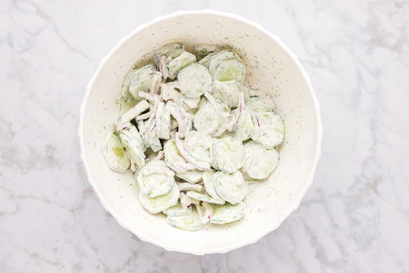 creamy cucumber salad mixed in a bowl