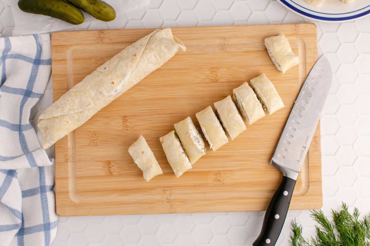 sliced dill pickle pinwheels on a cutting board