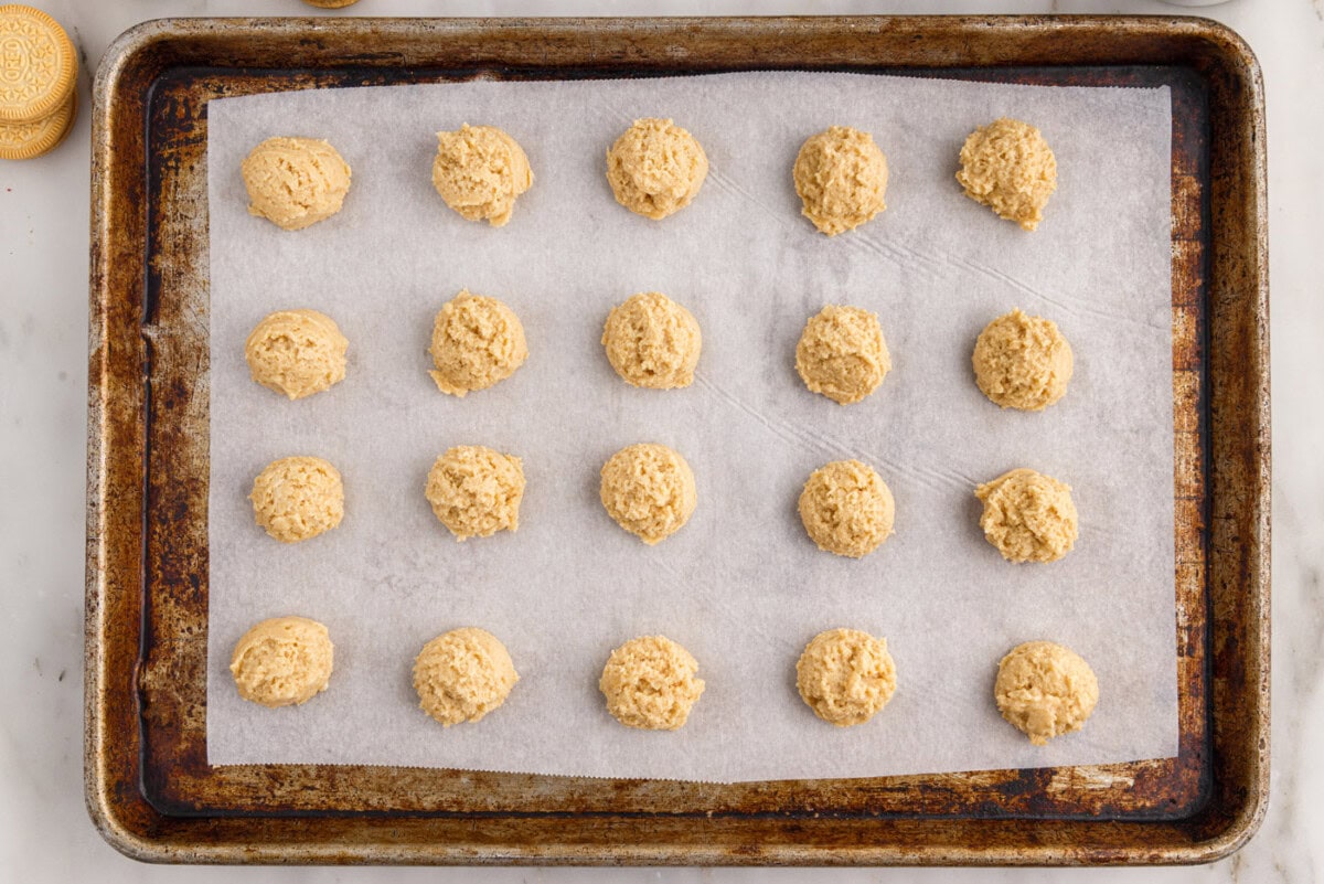 placing dough balls onto a parchment lined baking sheet