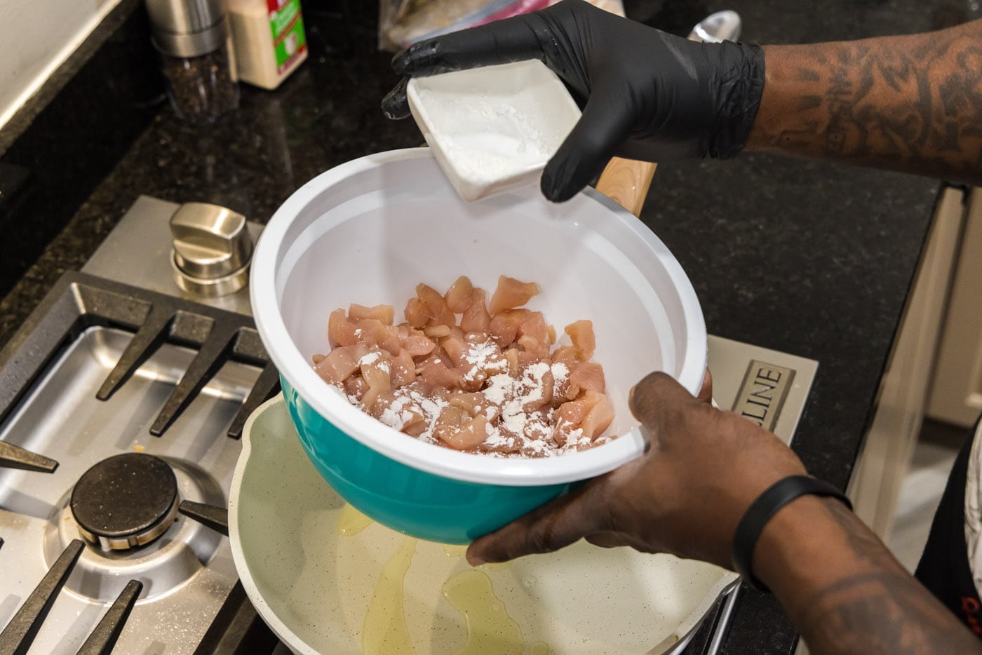 adding cornstarch to cubed chicken in a bowl
