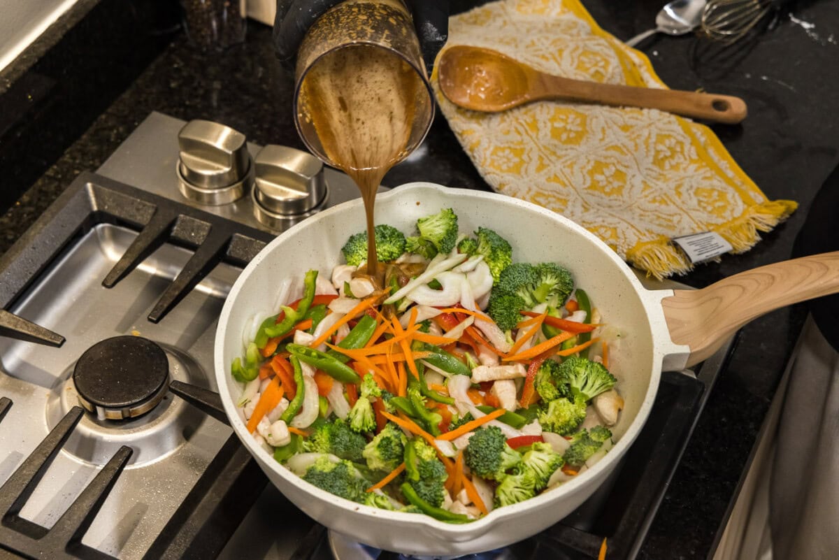 pouring sauce into stir fry skillet