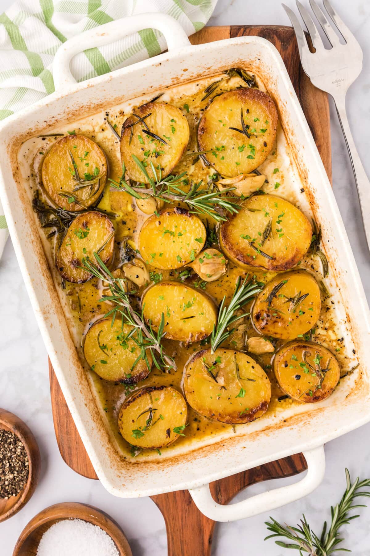 Melting Potatoes in a baking dish with rosemary garnish