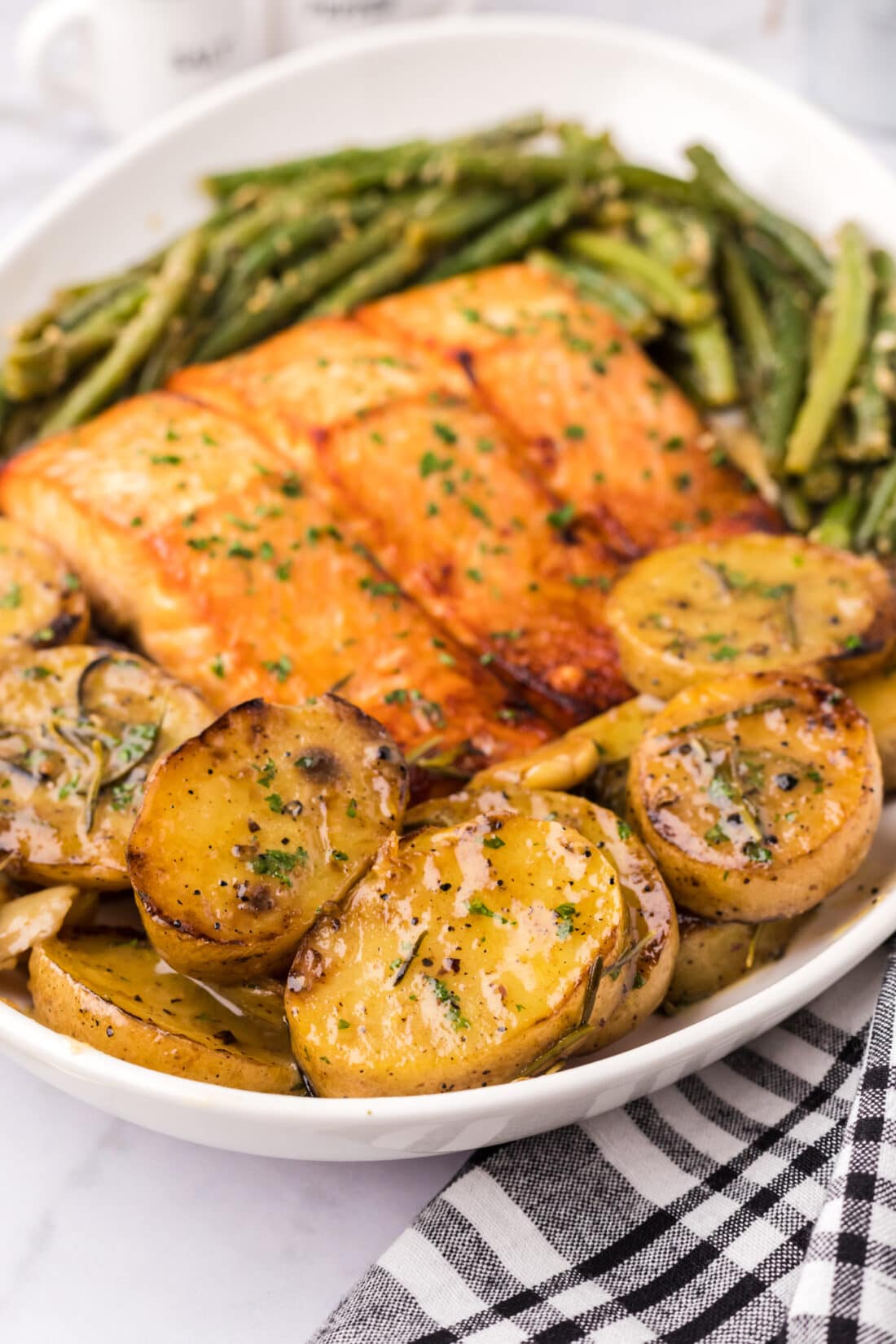 Melting Potatoes on a platter with garlic green beans and brown sugar salmon