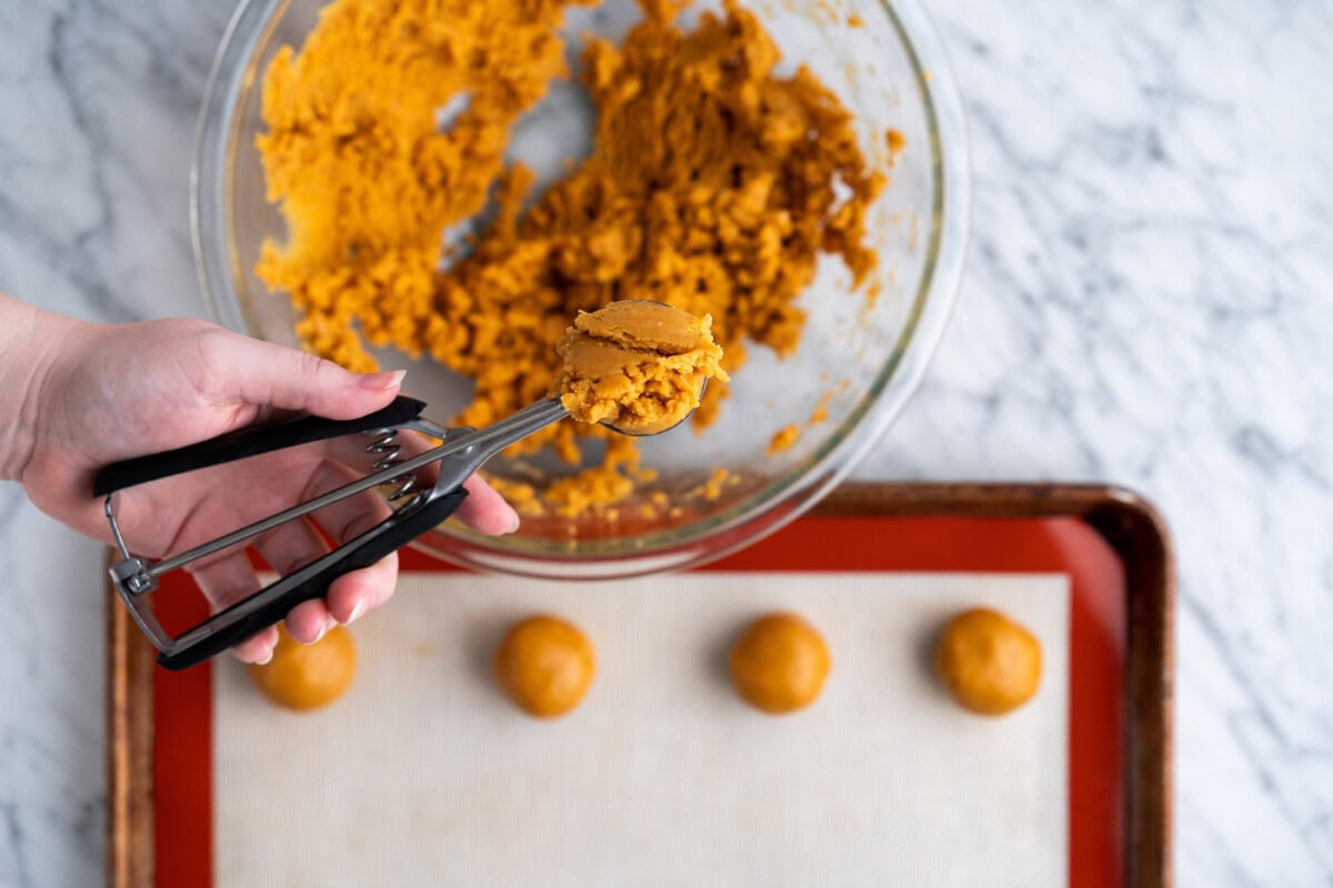 scooping peanut butter dough with a cookie scoop