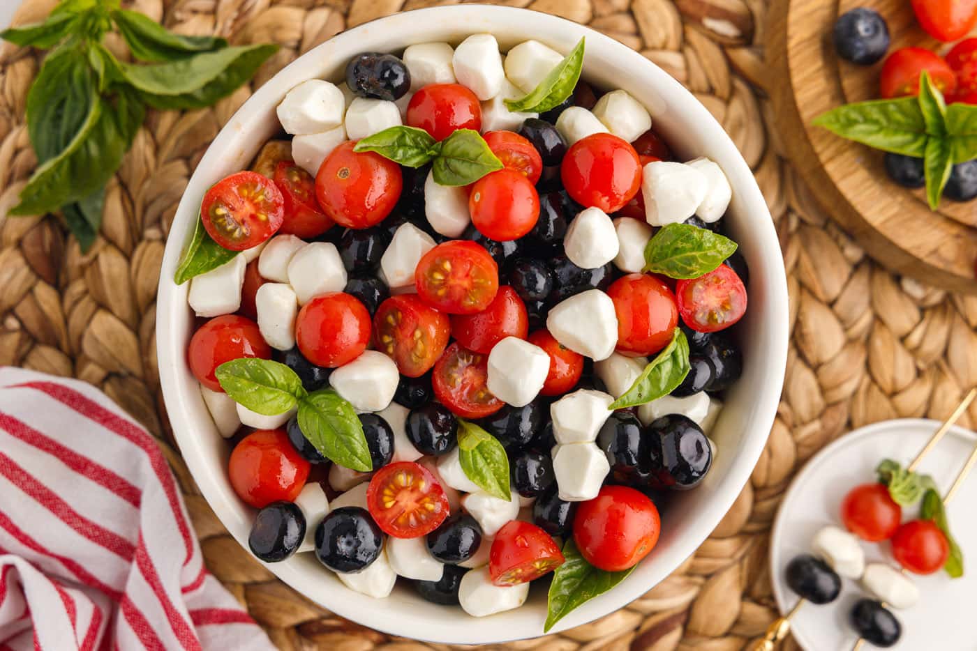 blueberries, mozzarella pearls, cherry tomatoes, and basil in a bowl
