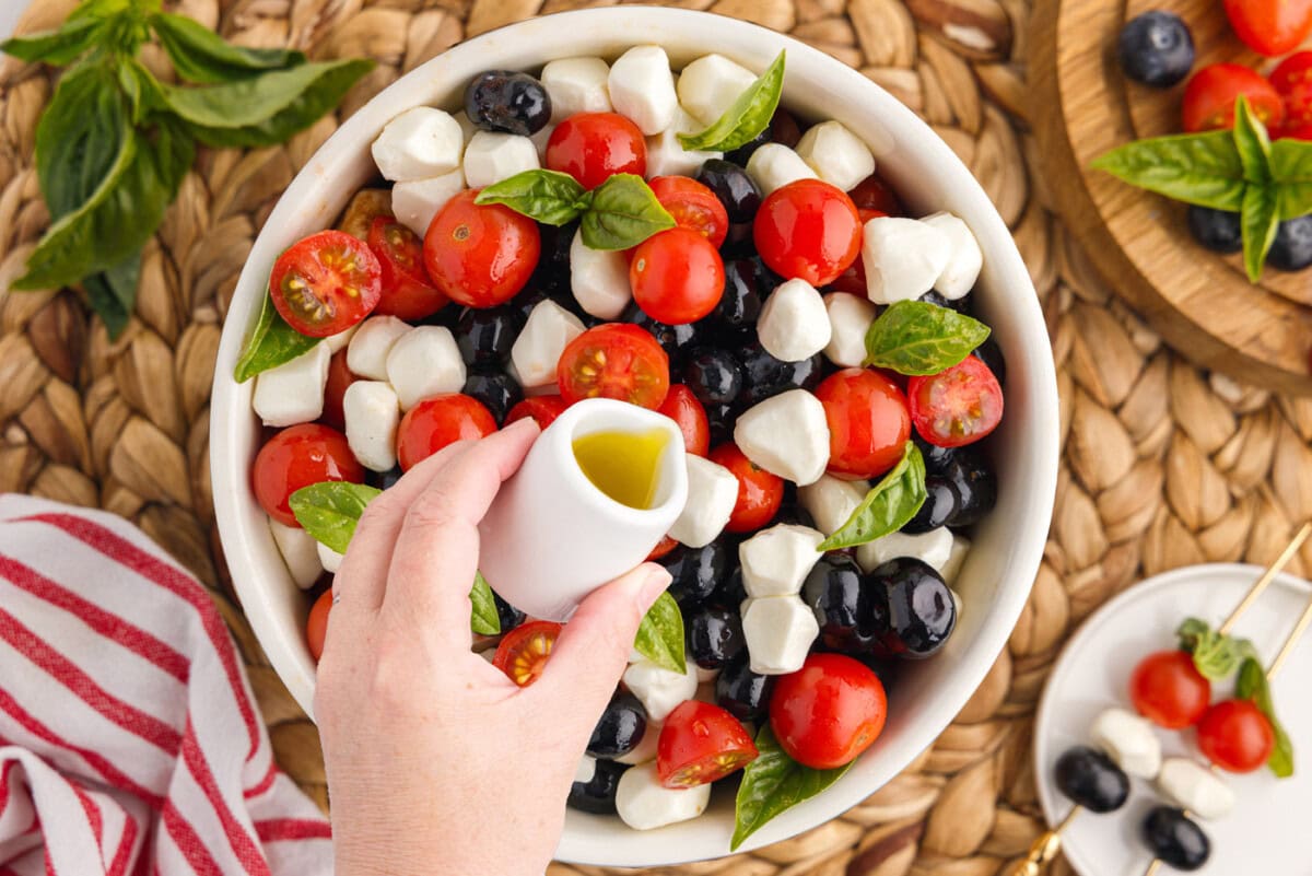drizzling balsamic glaze over patriotic caprese salad