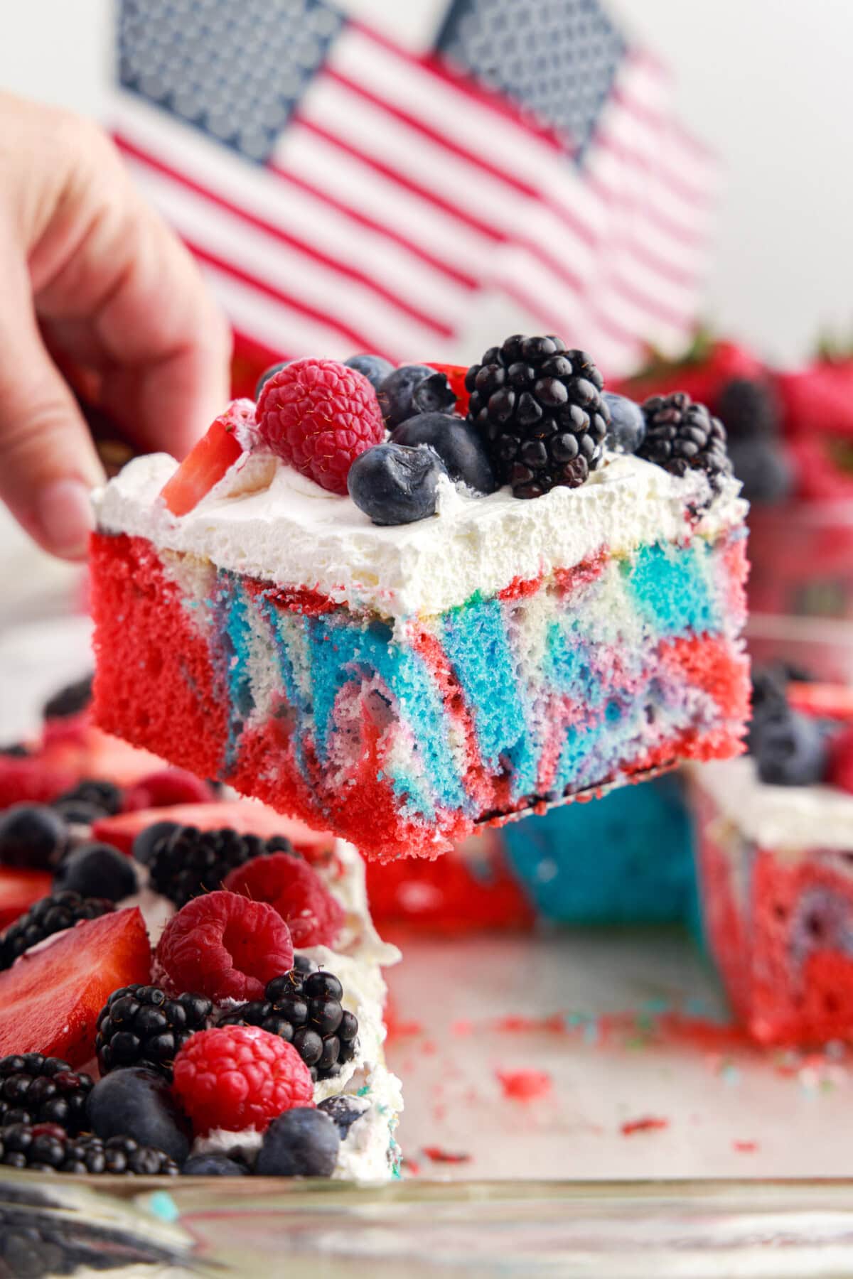 Piece of Red White and Blue Marble Cake being lifted out of the pan