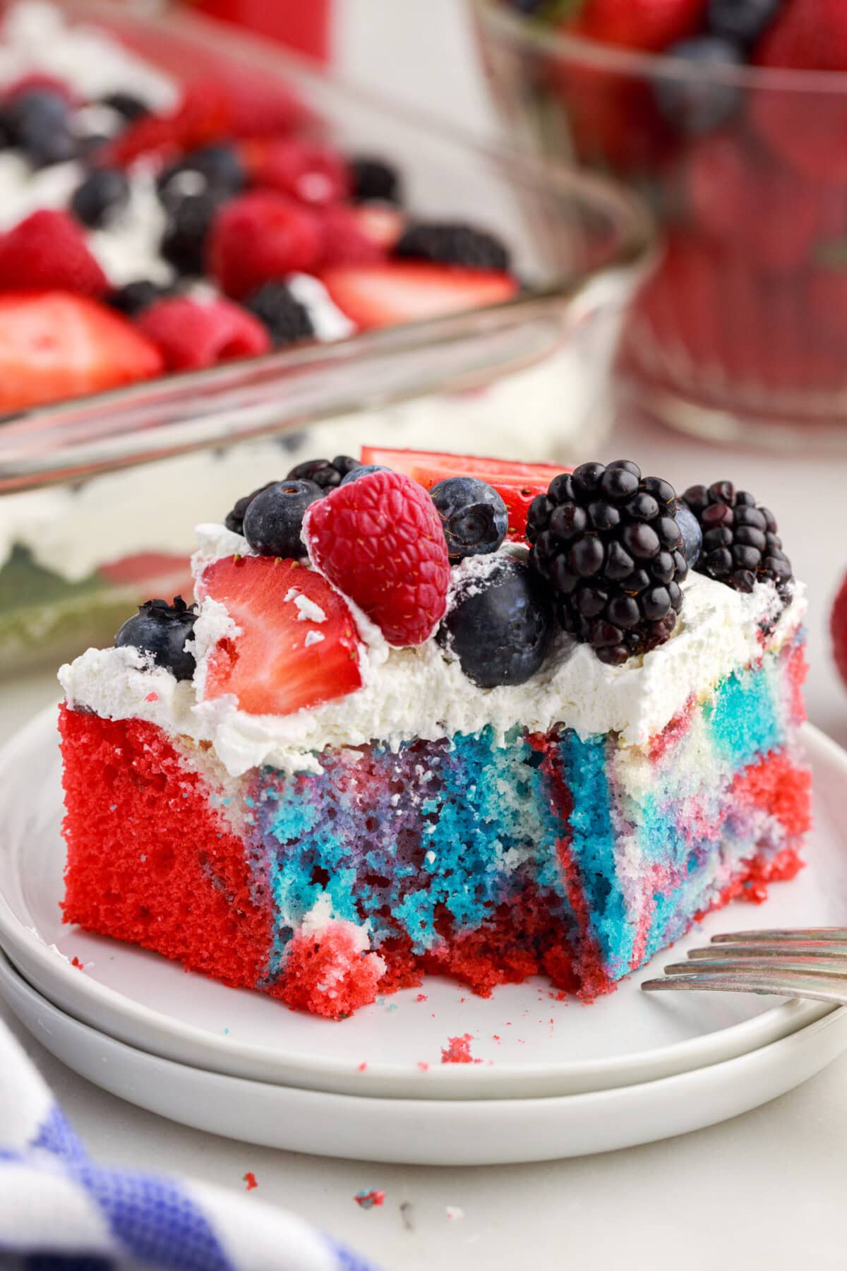 Piece of Red White and Blue Marble Cake on a plate with a bite taken out