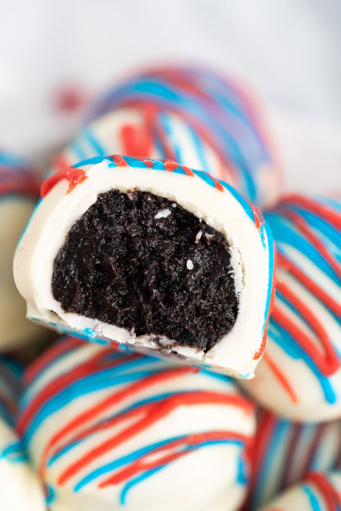 Close up photo of a Red White and Blue Oreo Truffle with a bite taken out