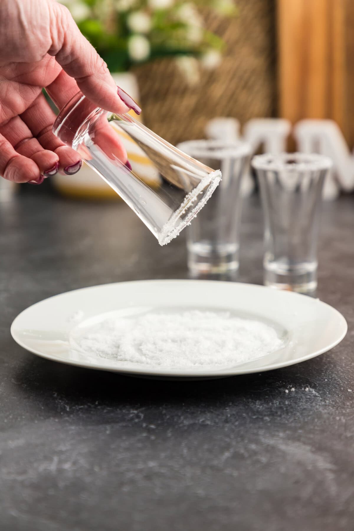 dipping wet shot glass rim into salt