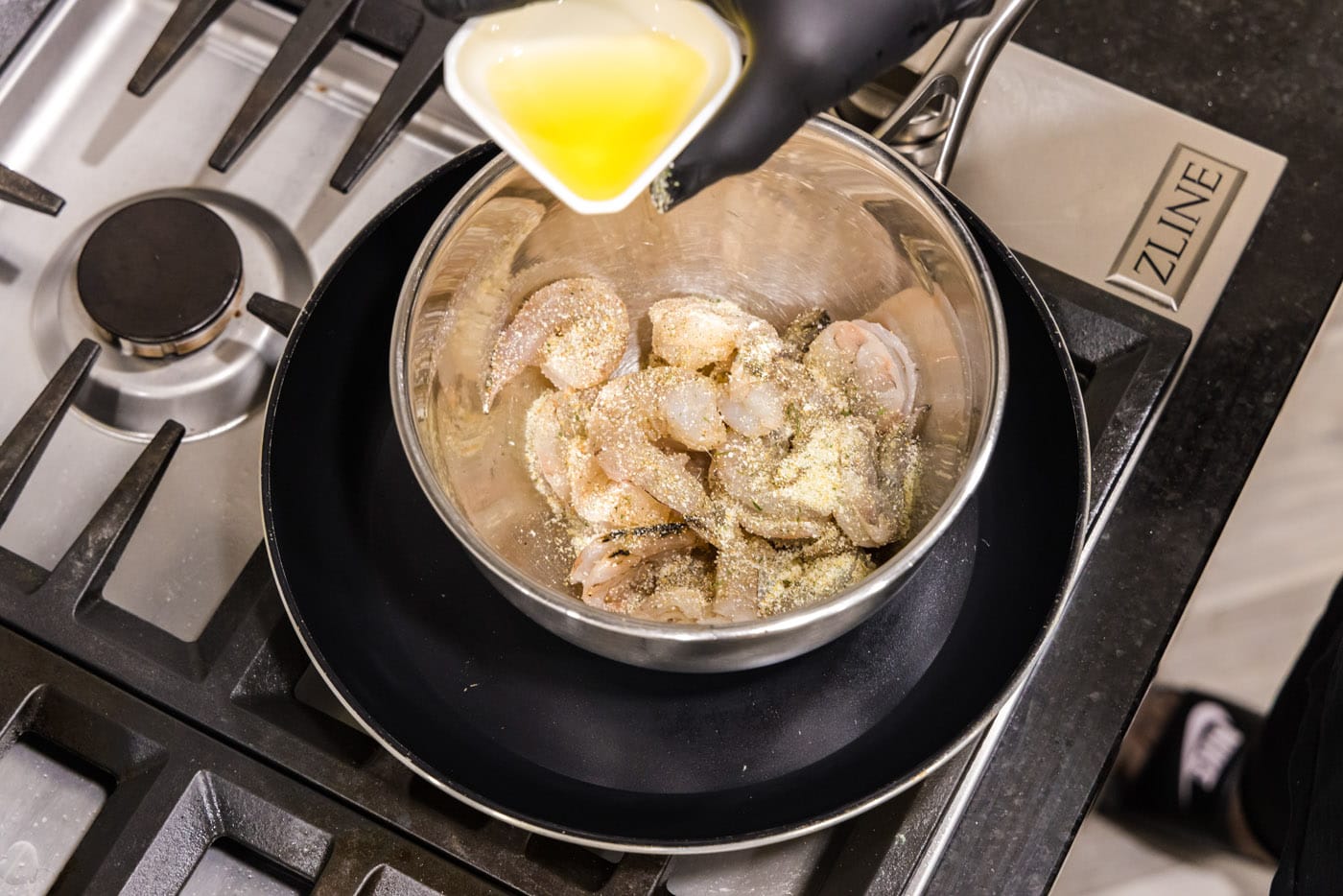 tossing shrimp with olive oil and garlic salt