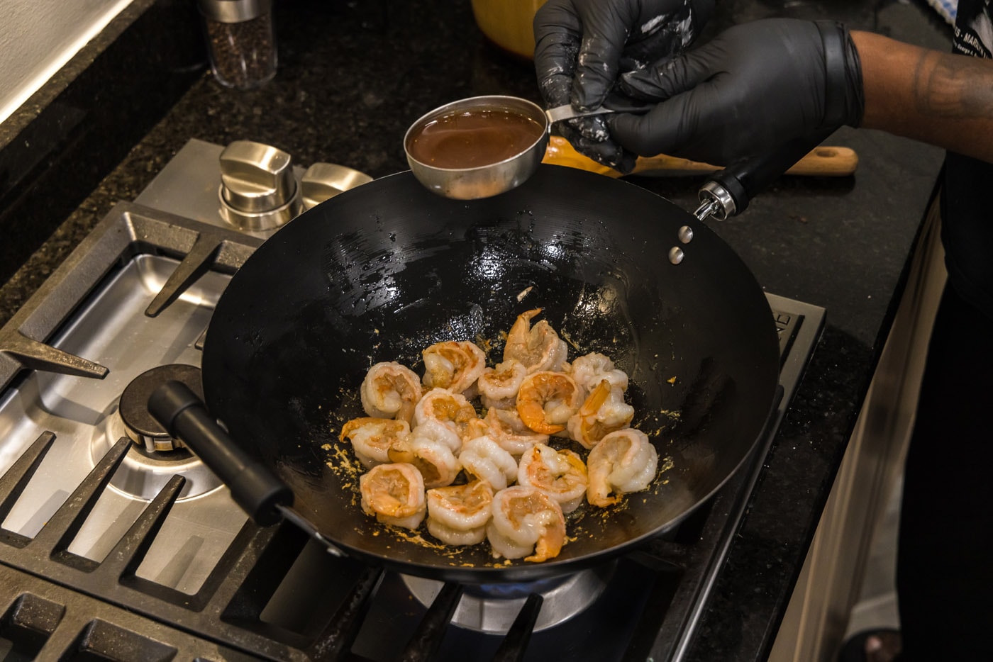 adding teriyaki sauce to shrimp in skillet