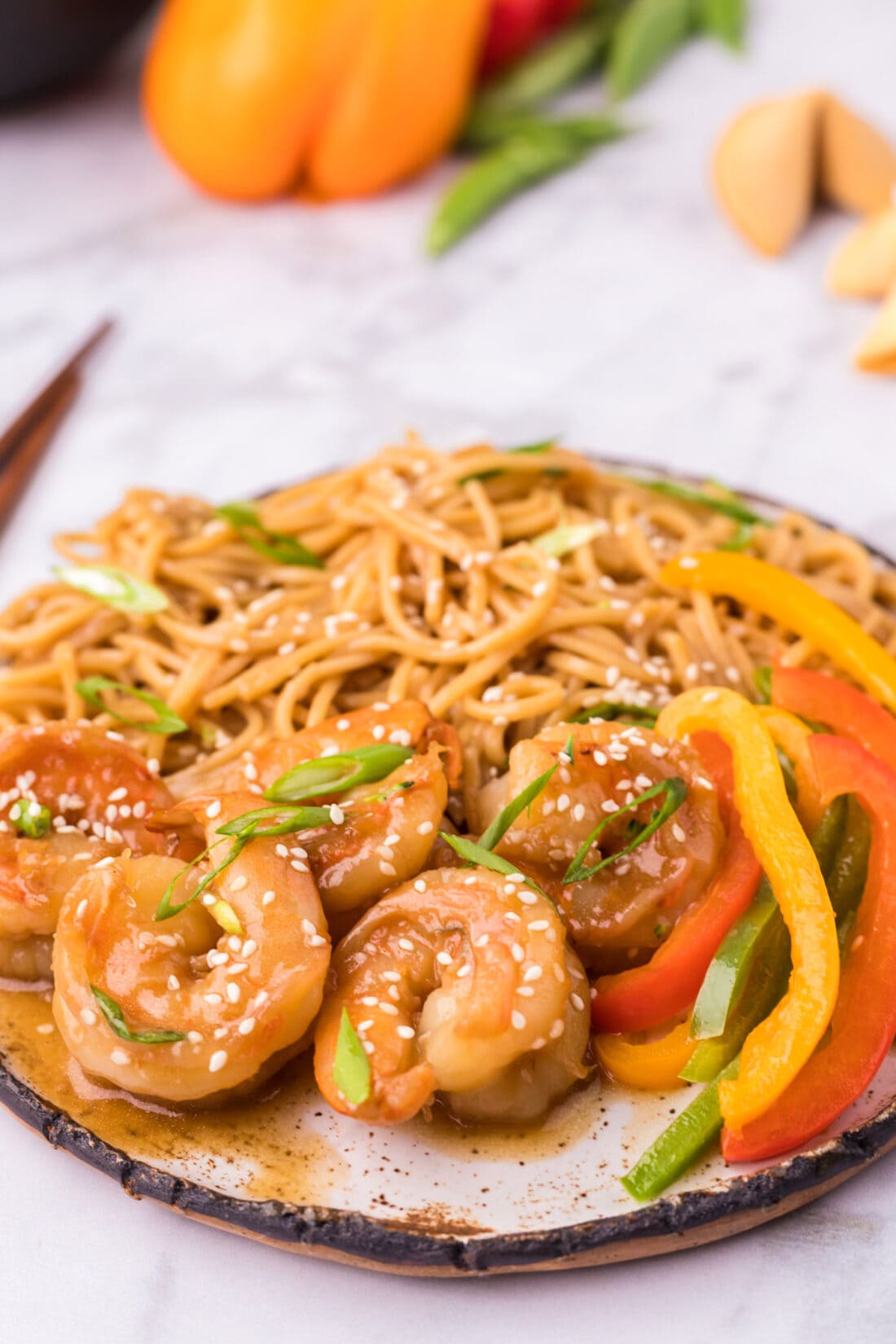 Teriyaki Shrimp on a plate with teriyaki noodles and sliced peppers