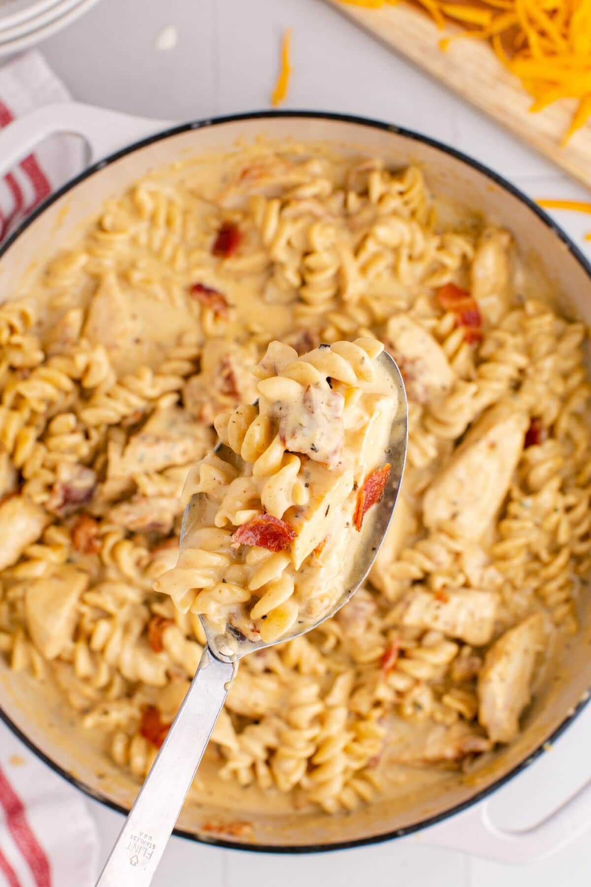 Spoonful of Bacon Chicken Ranch Pasta being lifted out of the pot of Bacon Chicken Ranch Pasta