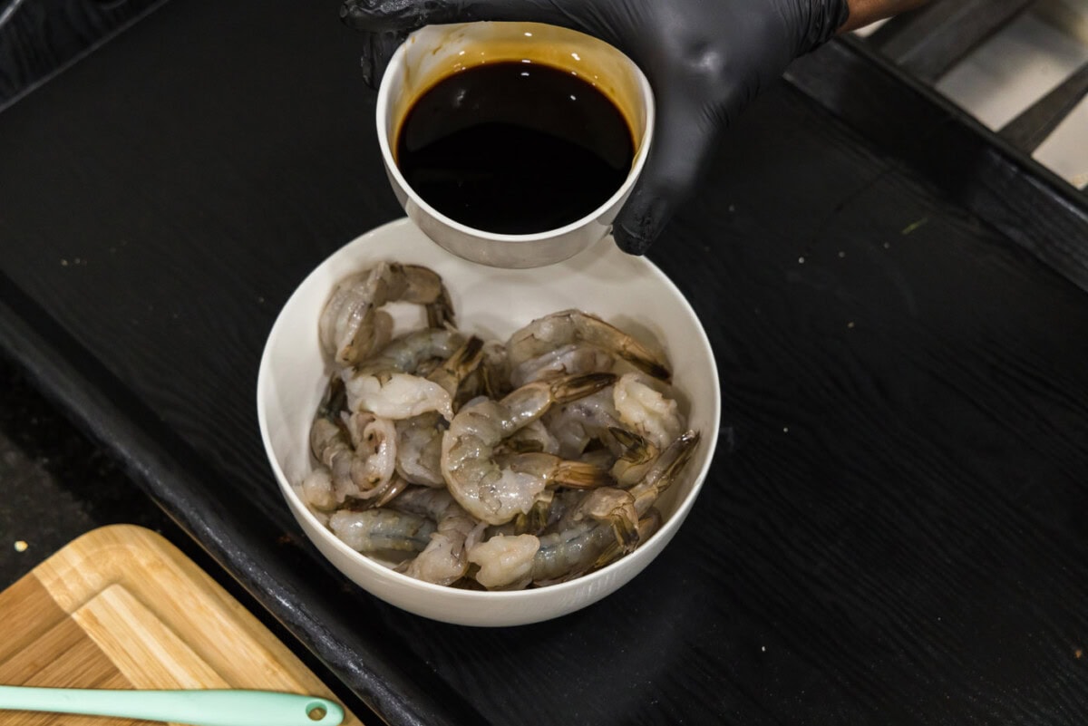pouring soy sauce honey glaze over shrimp