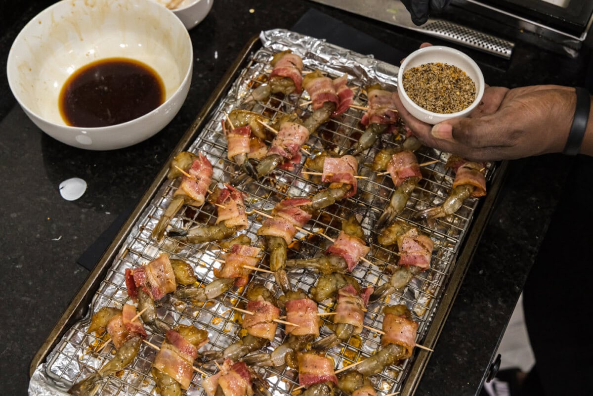 seasoning bacon shrimp on a baking sheet