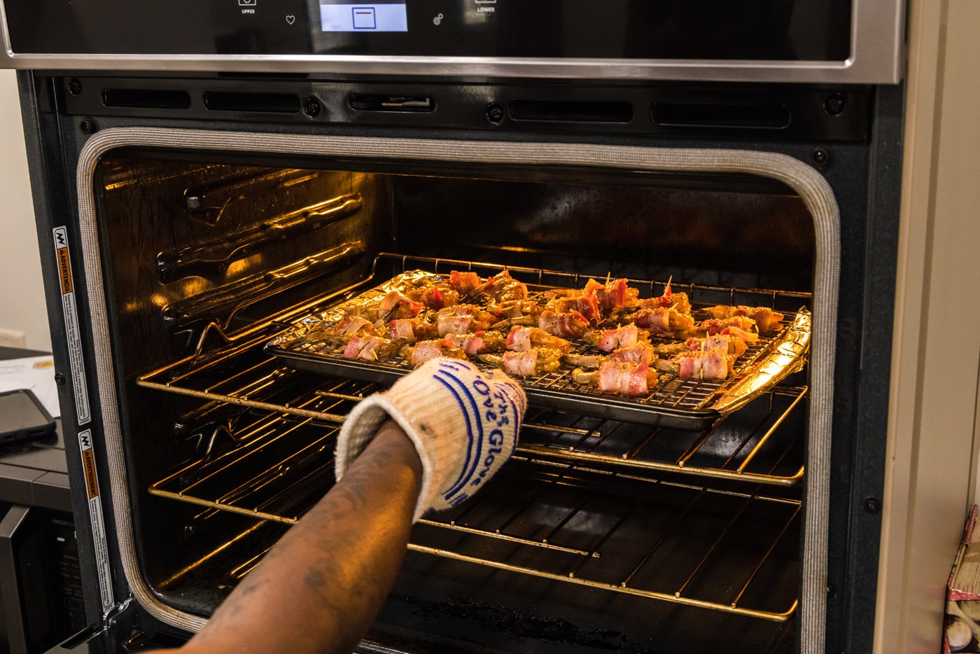 placing bacon wrapped shrimp into the oven