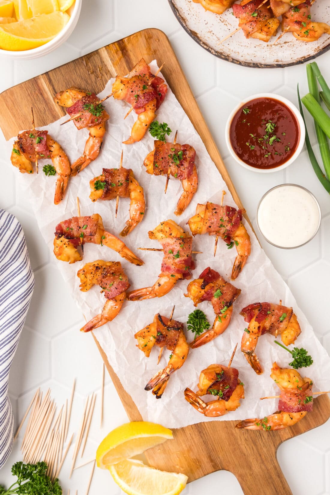 Bacon Wrapped Shrimp on a wooden platter with parchment paper