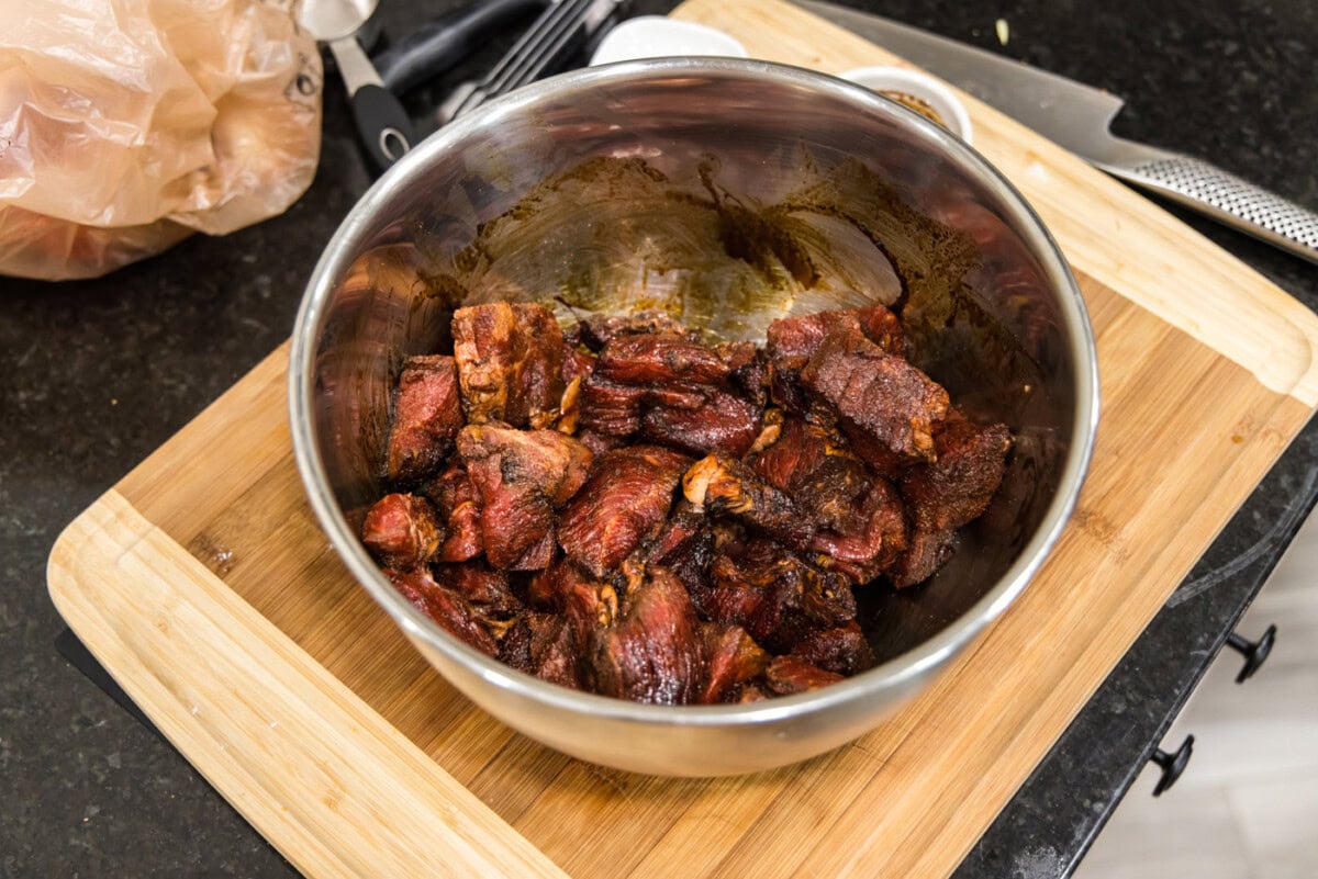 beef tips coated in browning sauce and seasoning in a bowl