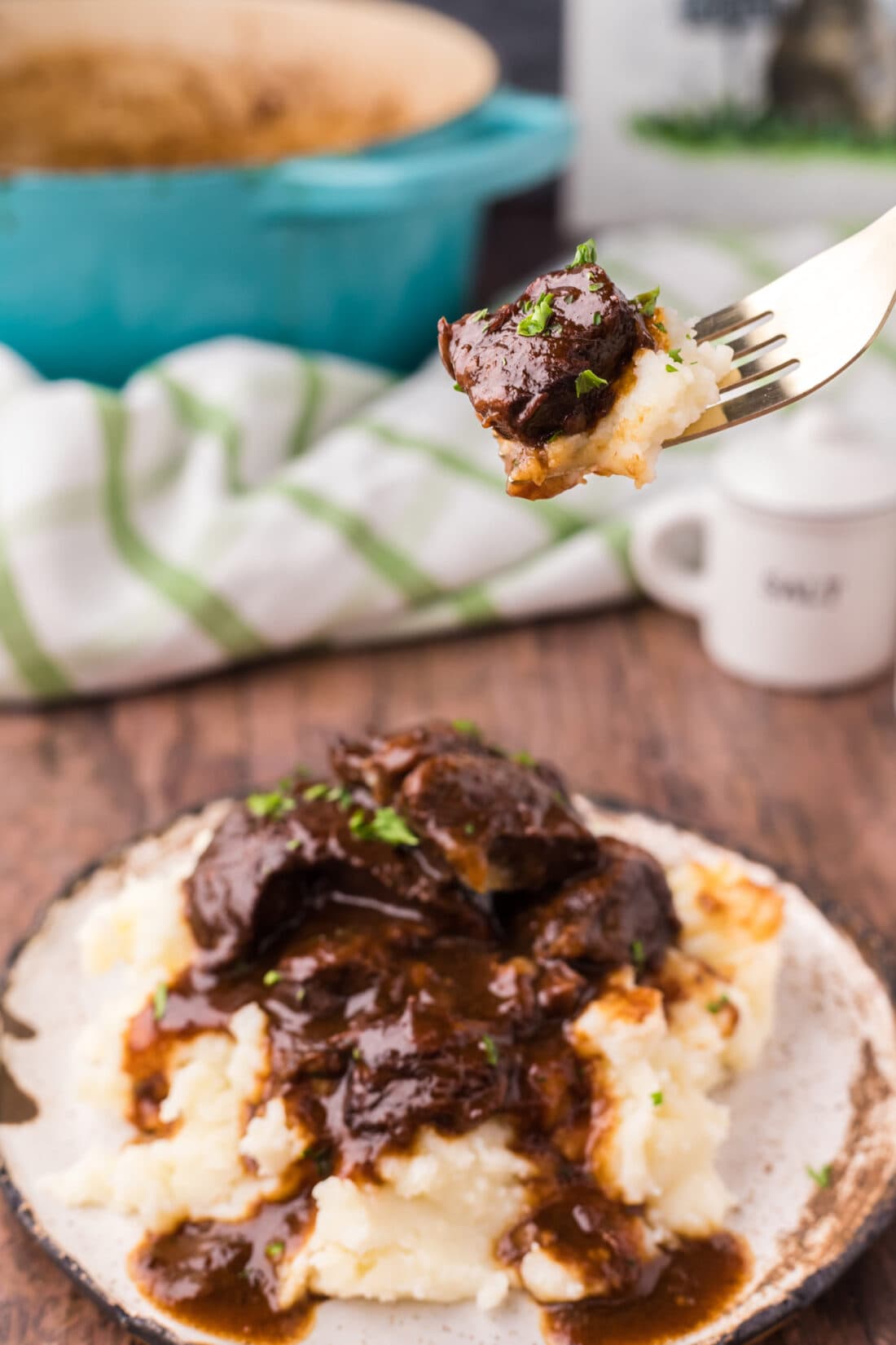Piece of Beef Tips and Gravy on a fork with mashed potatoes