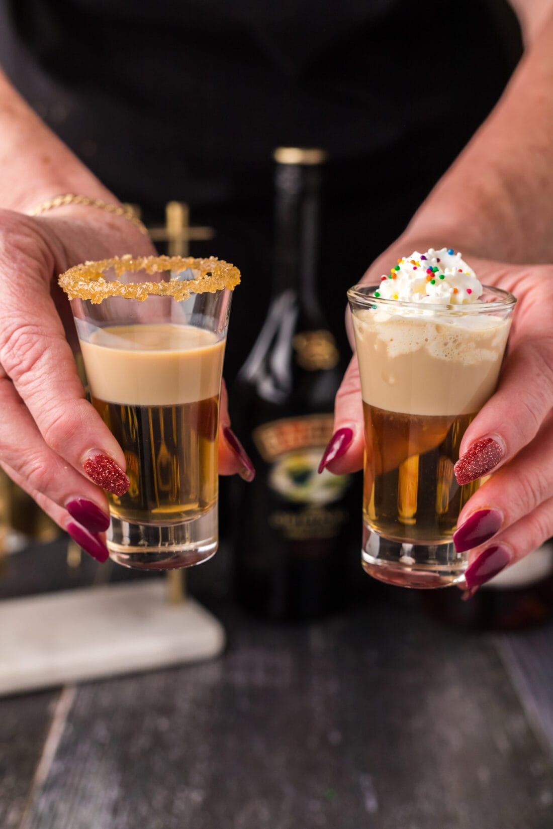 Two Buttery Nipple Shots being held up in the air