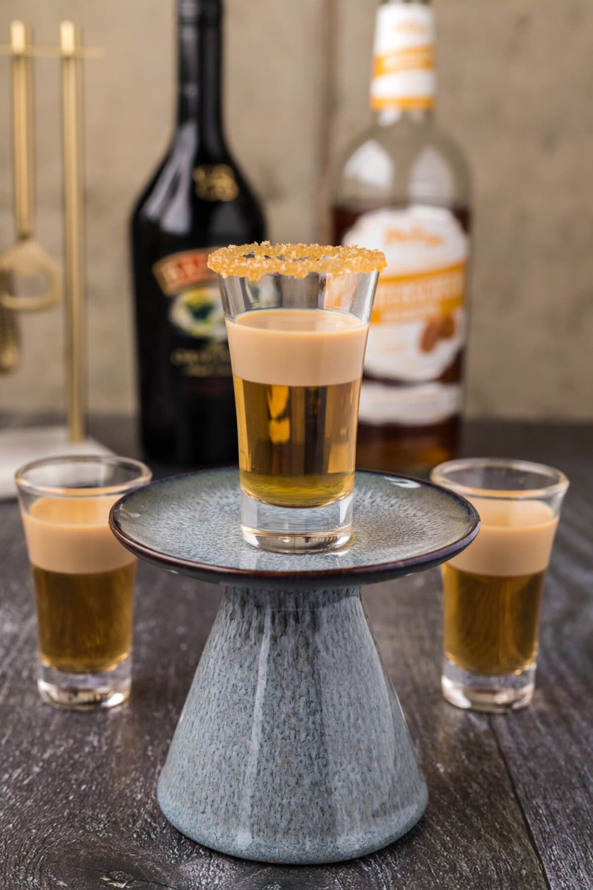 Buttery Nipple Shot resting on a cupcake stand