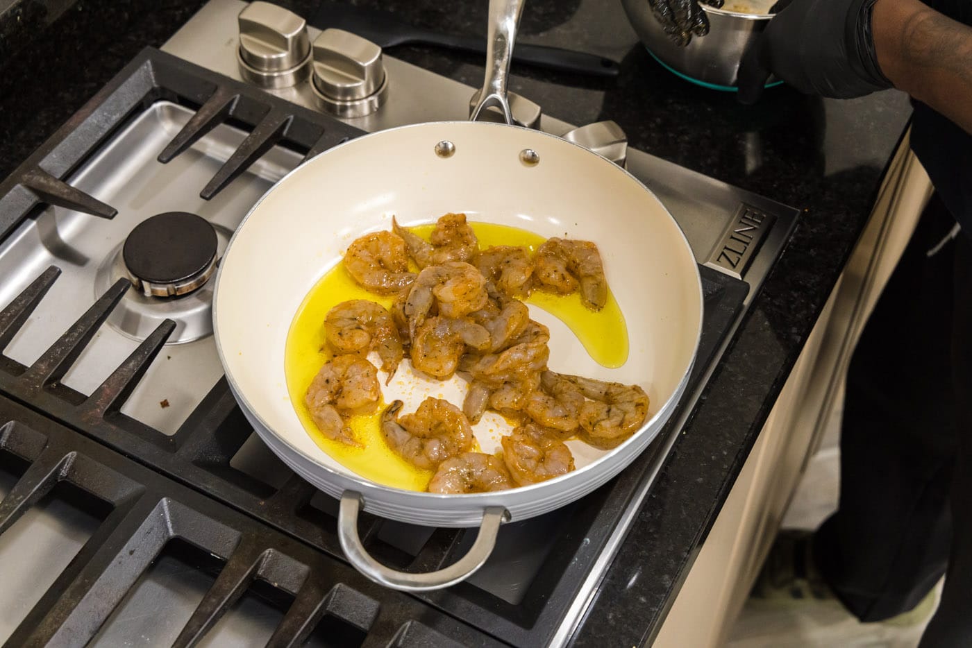 seasoned shrimp in a skillet with oil