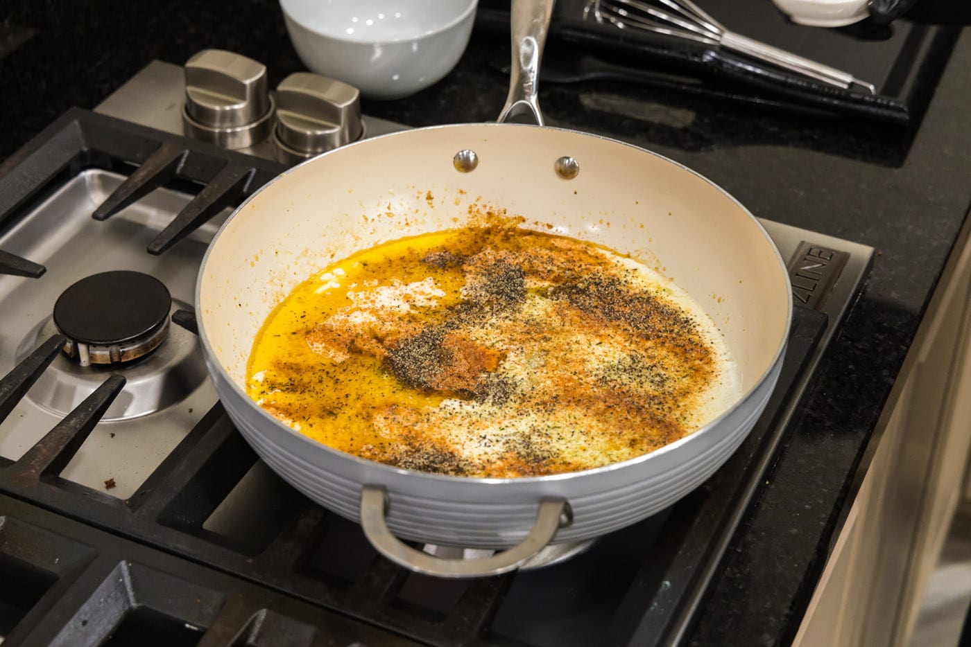 seasonings on top of parmesan cream sauce in skillet