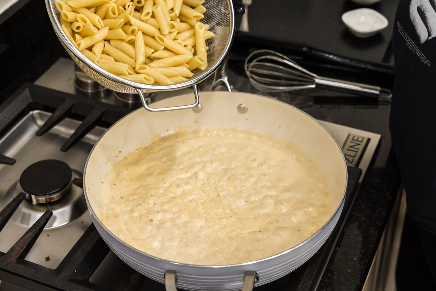 adding noodles to cream sauce