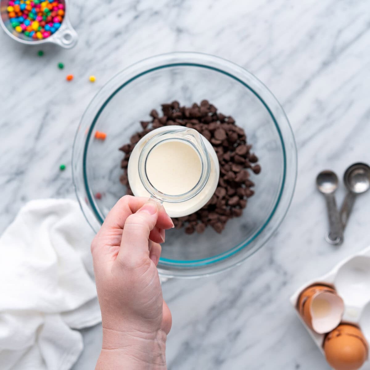 adding heavy whipping cream to chocolate chips for ganache