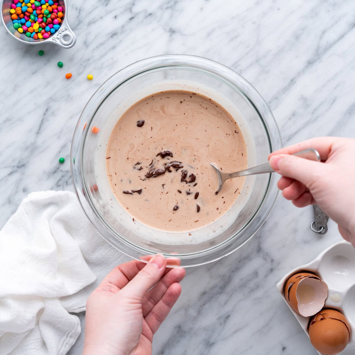 mixing chocolate chips and heavy whipping cream with a spoon