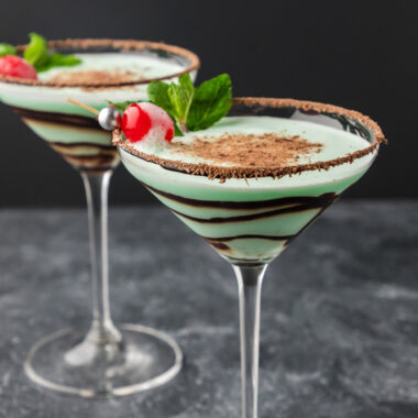 Two Grasshopper Drinks garnished with a cherry and mint sprig