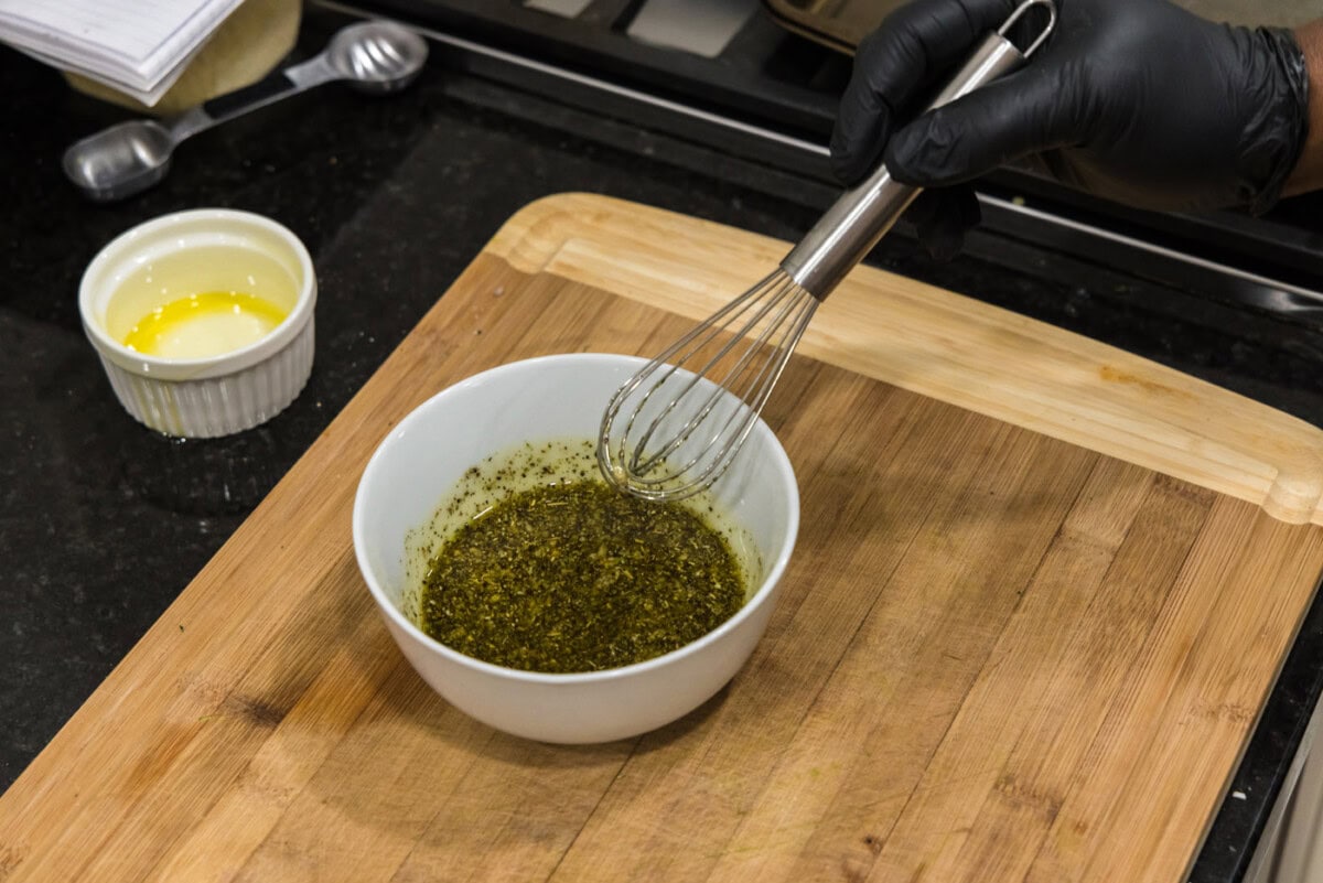 whisking grilled zucchini seasonings with oil