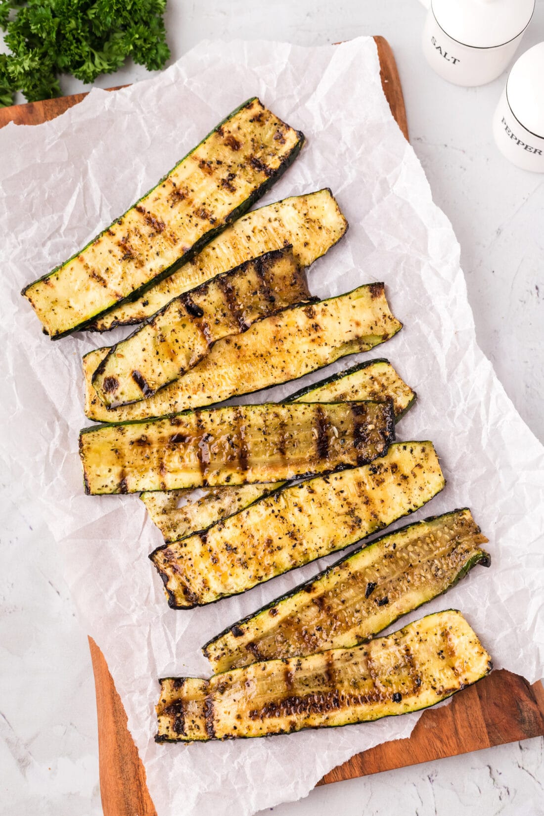 Grilled Zucchini on a wooden platter with parchment