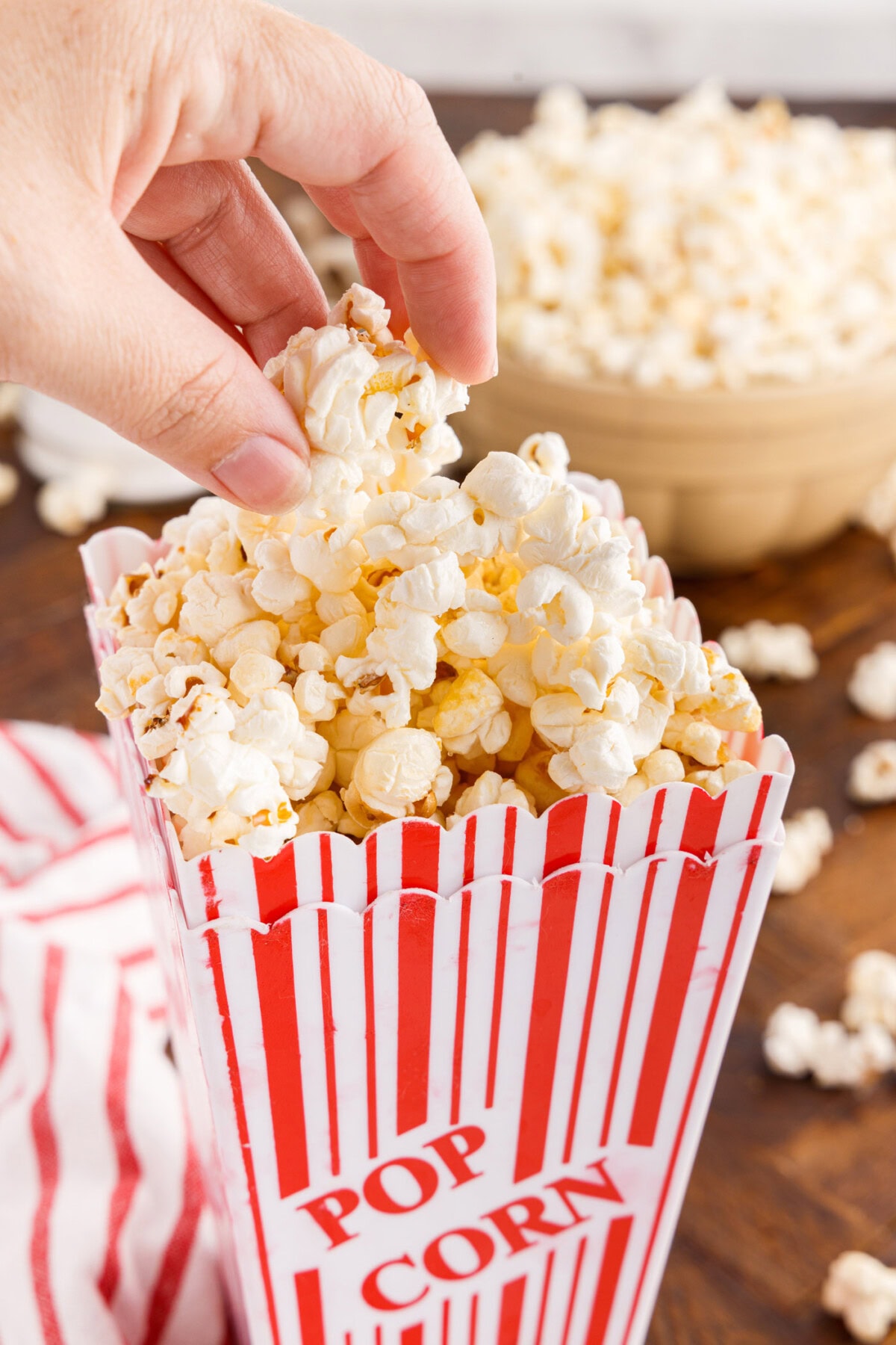 Hand grabbing Kettle Corn out of a popcorn bucket