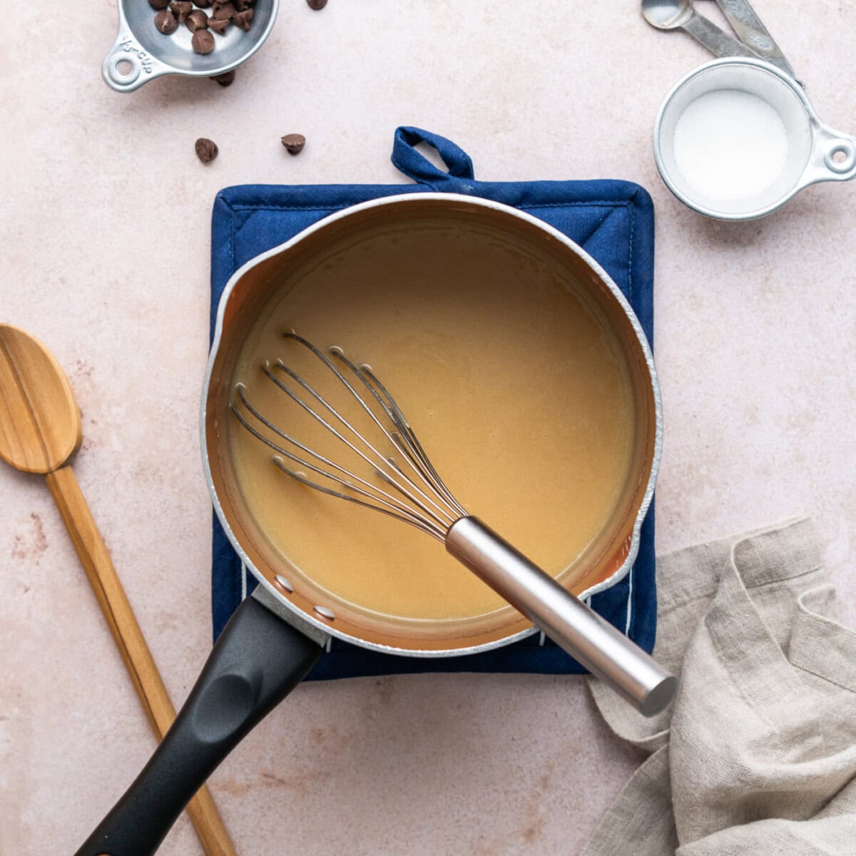 whisking homemade caramel in a saucepan