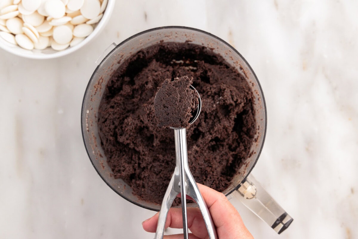 scooping out oreo dough from food processor