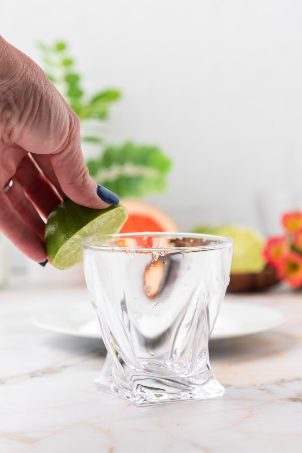 rubbing the rim of cocktail glass with lime