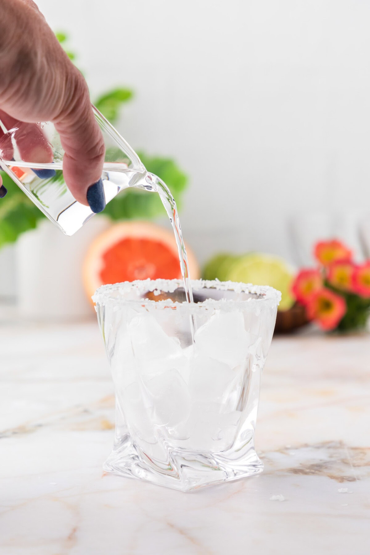 pouring tequila into rock glass