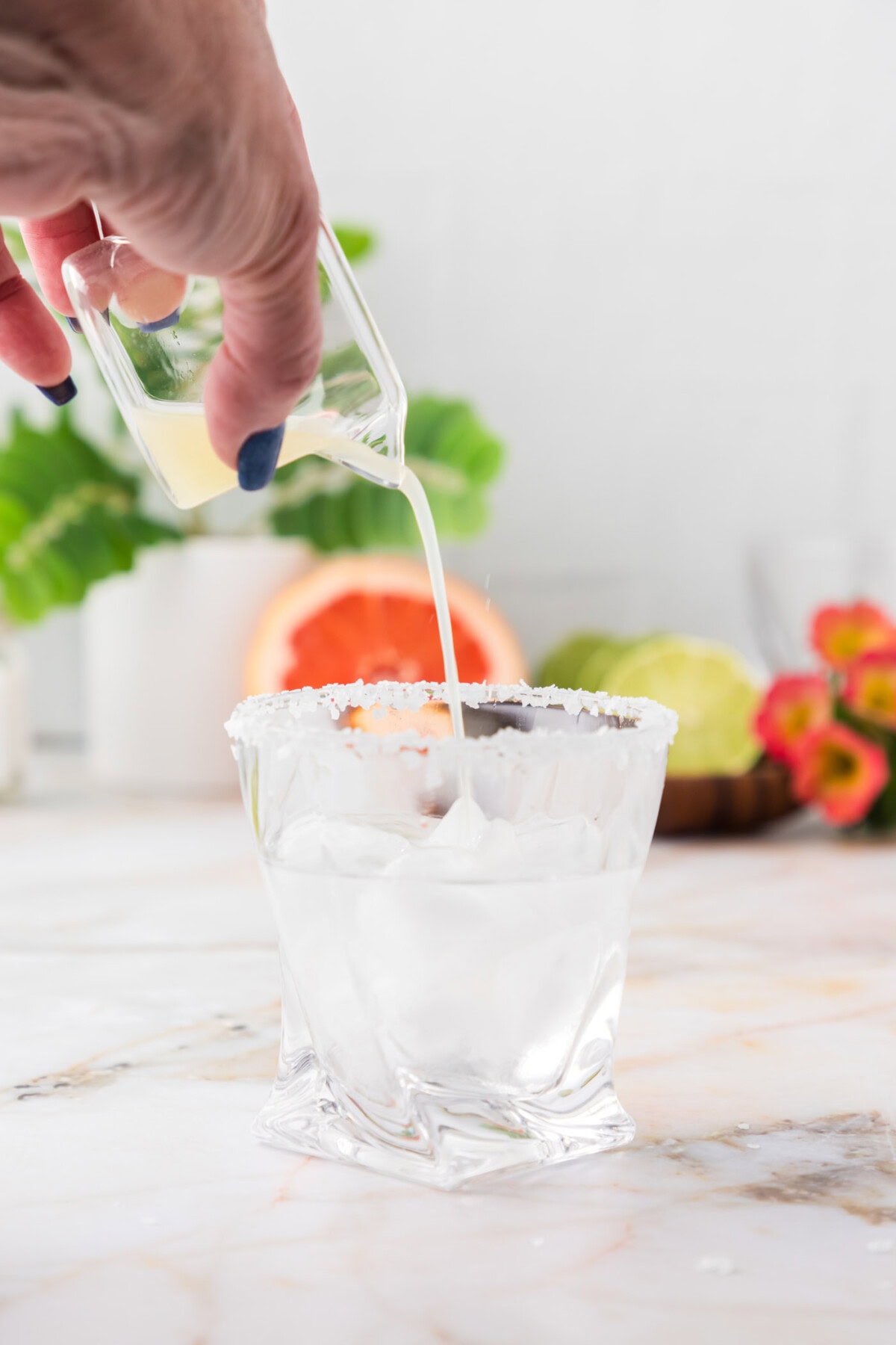pouring lime juice over blanco tequila