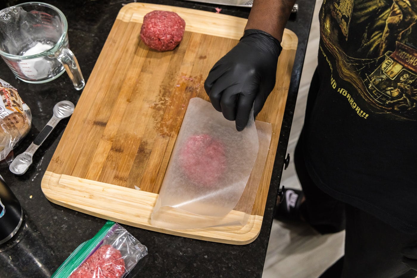 placing parchment paper over burger meat